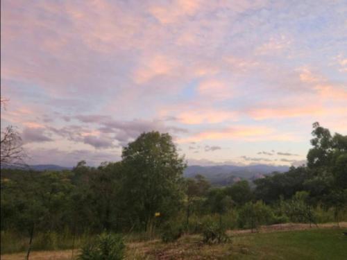 a cloudy sky with trees and mountains in the distance at The Sanctuary- Self Catering Accommodation in Nelspruit
