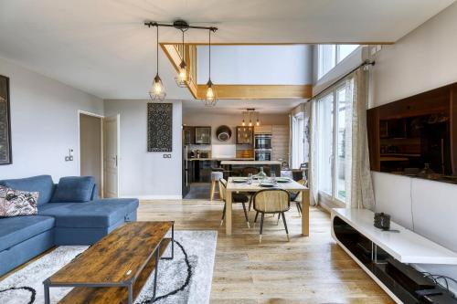 un salon avec un canapé bleu et une table dans l'établissement La Plume d'Hugo - Appt Duplex pour 8, à Saint-Ouen