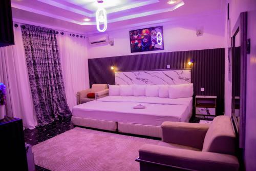 a bedroom with a large white bed and a couch at Skyrock Hotels Ikeja in Ikeja
