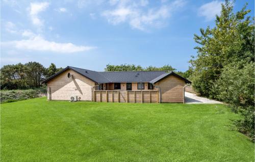 a large house with a large grass yard at Nice Home In Hvide Sande With Sauna in Bjerregård