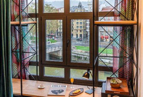 a room with a table and a window with a view at Axel Hotel Bilbao - Adults Only in Bilbao