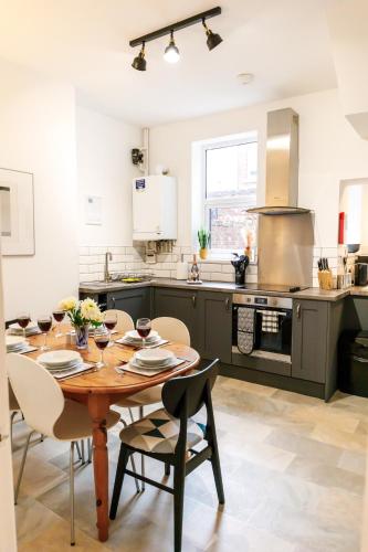 a kitchen with a wooden table and chairs in a kitchen at Bright and Well-Kept 3-Bed Property! Free Parking in Bishop Auckland