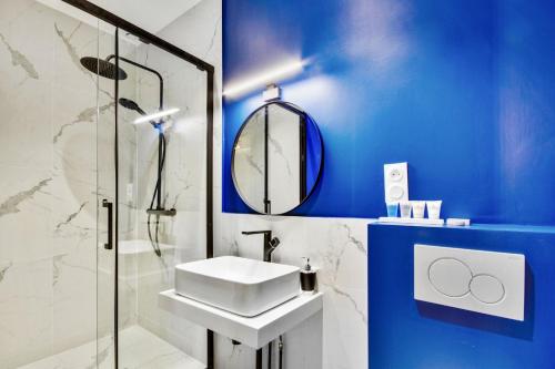 La salle de bains bleue est pourvue d'un lavabo et d'une douche. dans l'établissement 198 Suite Emma - Superb apartment in Paris, à Paris