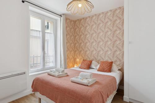 une chambre avec un lit avec des serviettes dessus dans l'établissement 863 Suite Hortensia - Superbe Appartement, à Montreuil