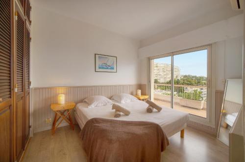 une chambre avec deux lits et une grande fenêtre dans l'établissement Le Val - Rooftop - Parking - VCA, à Cannes