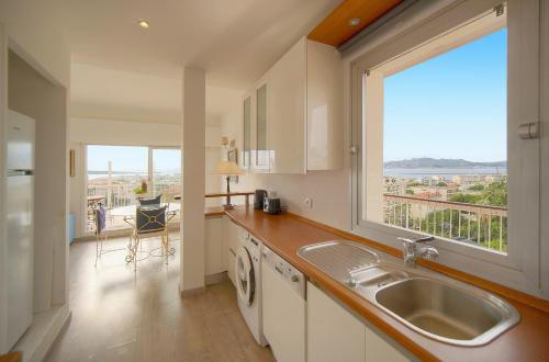 une cuisine avec un évier et une grande fenêtre dans l'établissement Le Val - Rooftop - Parking - VCA, à Cannes