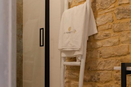 a white shirt hanging on a wall next to a shower at La Maison De Sofì - Luxury Suite & SPA in Bisceglie