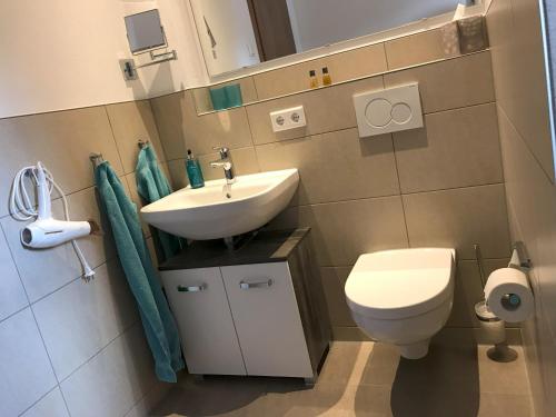 a bathroom with a white sink and a toilet at Appartementhaus Angelika in Nittenau