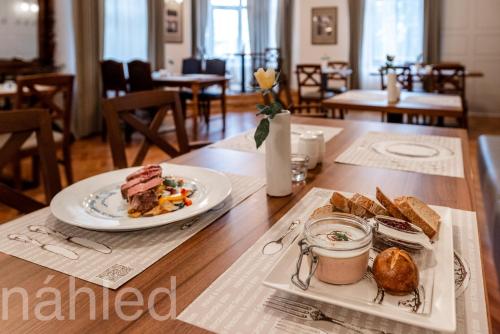 a table topped with a plate of food and bread at Hotel Švýcarský dům in Sněžnik
