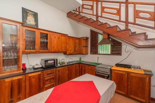 a large kitchen with wooden cabinets and a staircase at The Calm Of8 in Unawatuna