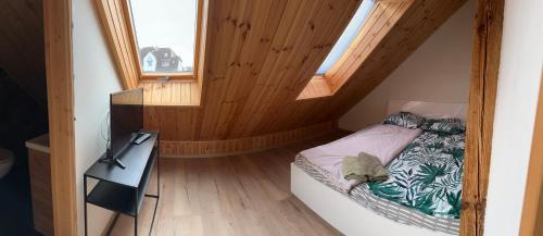 a small bedroom with a bed and a window at Apartamenty Bezrzecze in Szczecin