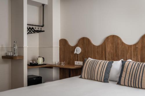 a bedroom with a bed with a wooden headboard and a desk at BYPILLOW Paseo in Alicante