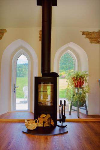 a living room with a fireplace and two windows at The Hornbill at Home Farm Shropshire in Shrewsbury