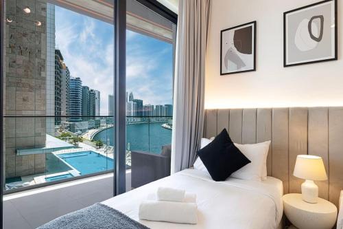 a bedroom with a bed and a large window with a view at Lux Apartment with huge private Lounge I Burj & Canal View in Dubai
