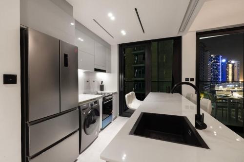 a kitchen with a refrigerator and a sink in it at Lux Apartment with huge private Lounge I Burj & Canal View in Dubai