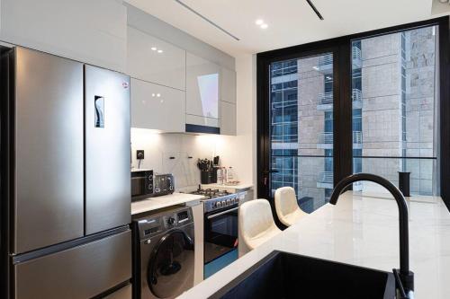 a kitchen with a stainless steel refrigerator and appliances at Lux Apartment with huge private Lounge I Burj & Canal View in Dubai