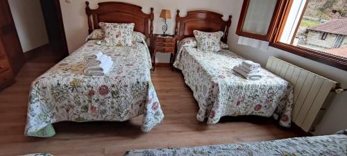 a bedroom with two beds and a window at Apartamento Rural Juana in Alles
