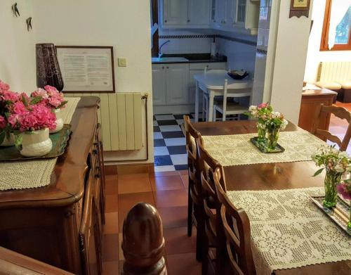 a kitchen with two tables and chairs with flowers on them at Apartamento Rural Juana in Alles