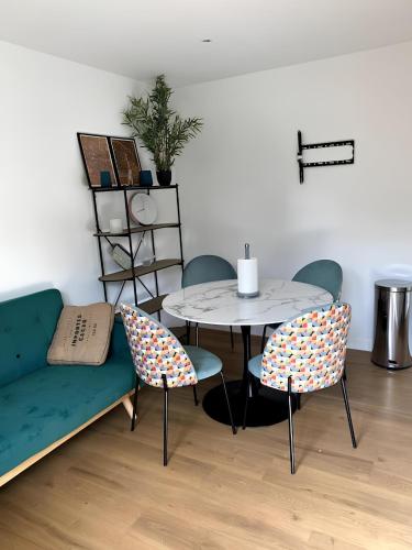 un salon avec une table, des chaises et un canapé dans l'établissement 2BR 2 bathroom Geneva Tram 17, à Ambilly