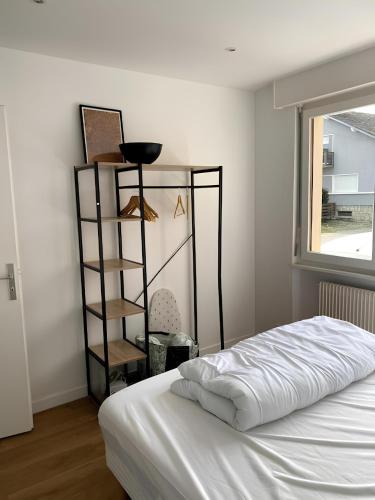 - une chambre avec un lit blanc et une étagère dans l'établissement 2BR 2 bathroom Geneva Tram 17, à Ambilly