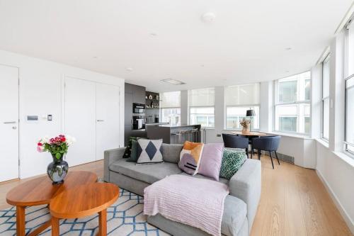 a living room with a couch and a table at Perfect One Bed in Green Park Station in London