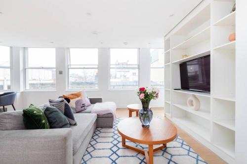 a living room with a couch and a table at Perfect One Bed in Green Park Station in London