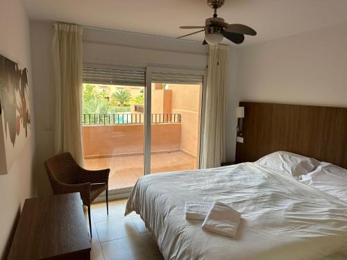 a bedroom with a bed and a view of a patio at Mar Menor Golf Resort 2 Bed Apartment in Los Martínez