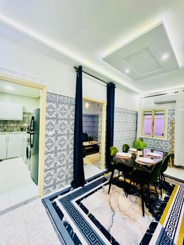 a living room with a table and a kitchen at Apartment with AC and a nice private terrace Appartement CLIMATISÉ avec une jolie terrasse privée in Marrakech