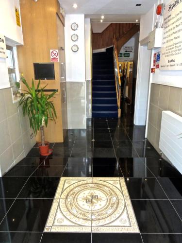 a lobby with a tile floor and a staircase at Skylark Guest House in Hounslow