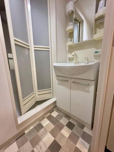 un baño con lavabo y espejo en 410札幌駅徒歩7分と大通駅徒歩6分で好立地な都心を満喫でき綺麗な部屋で快適が生活が実現, en Sapporo