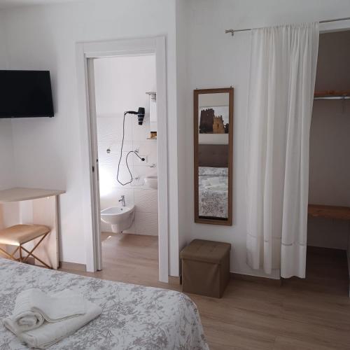 a white room with a bed and a bathroom at Casa Vacanze B&B Ondes in Camerota