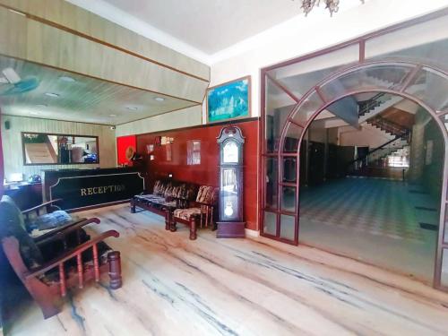 a living room with a clock in the middle of a room at Hotel Hill Town Coorg in Madikeri
