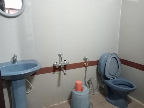 a bathroom with a blue toilet and a sink at Hotel Hill Town Coorg in Madikeri