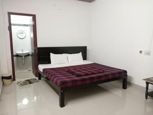 a bedroom with a bed and a sink and a mirror at Hotel Hill Town Coorg in Madikeri