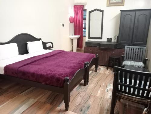 a bedroom with a bed and a vanity and a mirror at Hotel Hill Town Coorg in Madikeri