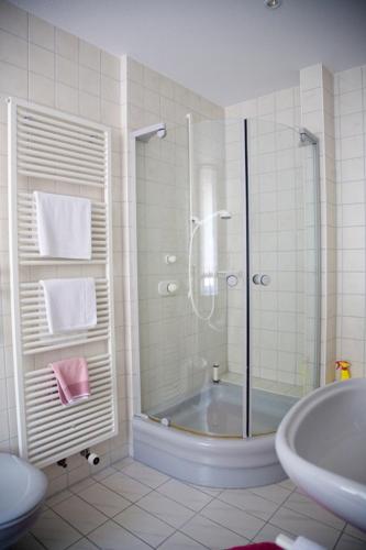 a bathroom with a shower and a tub and a sink at Gasthaus Merkel Hotel in Bad Berneck im Fichtelgebirge