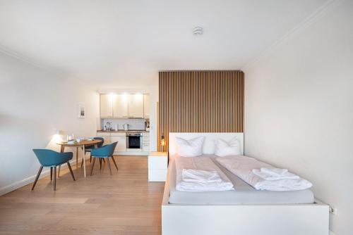 Un dormitorio con una cama y una mesa y sillas. en Ferienwohnung Waves, en Travemünde