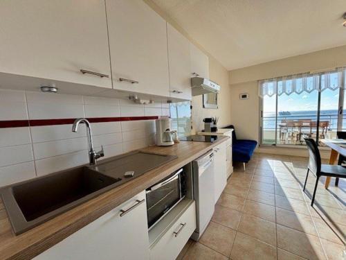 - une cuisine avec un évier et un comptoir avec une table dans l'établissement Quiberon: Appartement 2 pièces, 35m², vue mer, garage privé - FR-1-478-303, à Quiberon