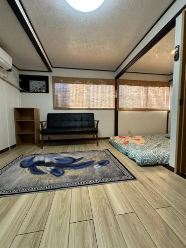 ein Wohnzimmer mit einem Bett und einer Couch in der Unterkunft 青砥駅徒步5分 Aoto だるま宿 in Tokio
