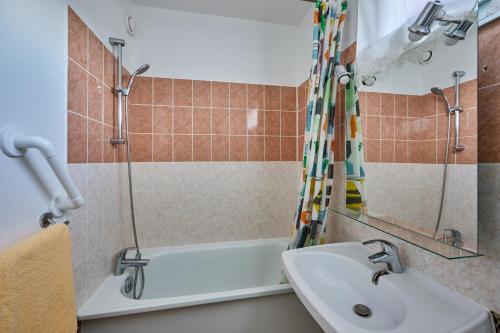 une salle de bain avec un lavabo et une douche dans l'établissement L'Escale du Cap Horn - Appt 4p à 1km de la mer, à Courseulles-sur-Mer