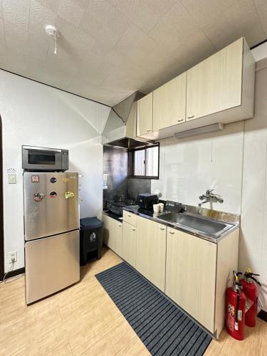 a kitchen with a stainless steel refrigerator and a sink at 青砥駅徒步5分 Aoto だるま宿 in Tokyo