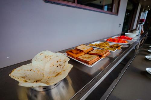 - un buffet avec différents types de nourriture dans l'établissement The Odyssey Coorg, à Madikeri