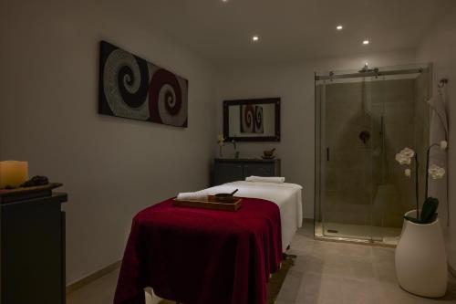 a bathroom with a bed and a glass shower at Almar Timi Ama Resort & Spa in Villasimius