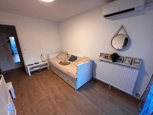une petite chambre avec un lit et un miroir dans l'établissement Studio Silver Oaks, à La Grande Motte