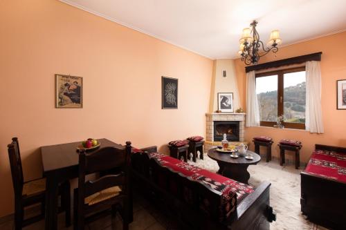 a living room with a table and chairs and a fireplace at Amygdalies Apartments with Fireplace in Karpenision