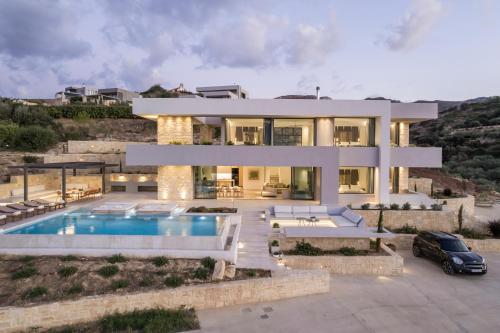 a villa with a swimming pool in front of it at Youphoria Sea View Villas in Kissamos