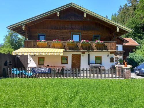 a house with a balcony with flowers on it at Haus Bachrauschen in Kirchanschöring