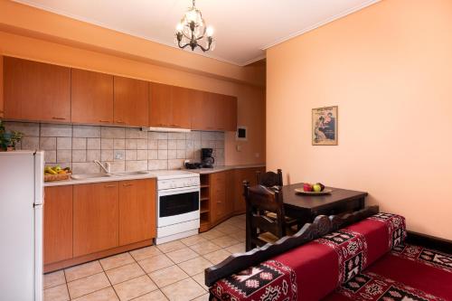 a kitchen with a couch and a table in a room at Amygdalies Apartments with Fireplace in Karpenision