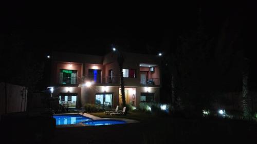 a house at night with a pool in front of it at Villa isouktan in Sbiti