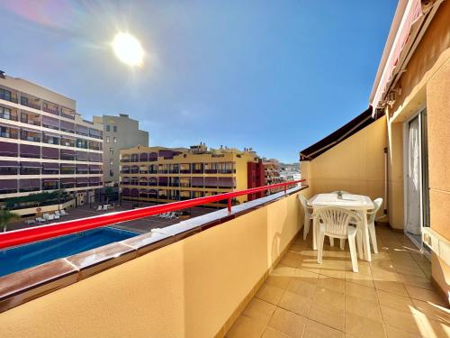 Un balcón con una mesa y vista a una ciudad. en Santiago Sun, en Puerto de Santiago